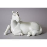 A ORIENTAL WHITE GLAZED PORCELAIN MODEL OF A RECUMBENT HORSE, possilby Hirado, 20th century, 10.