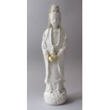 A 18TH / 19TH CENTURY CHINESE BLANC DE CHINE FIGURE OF GUANYIN, stood holding a young child in her