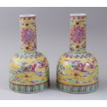 A PAIR OF EARLY 20TH CENTURY CHINESE BELL SHAPED FAMILLE ROSE PORCELAIN VASES, with a lappet