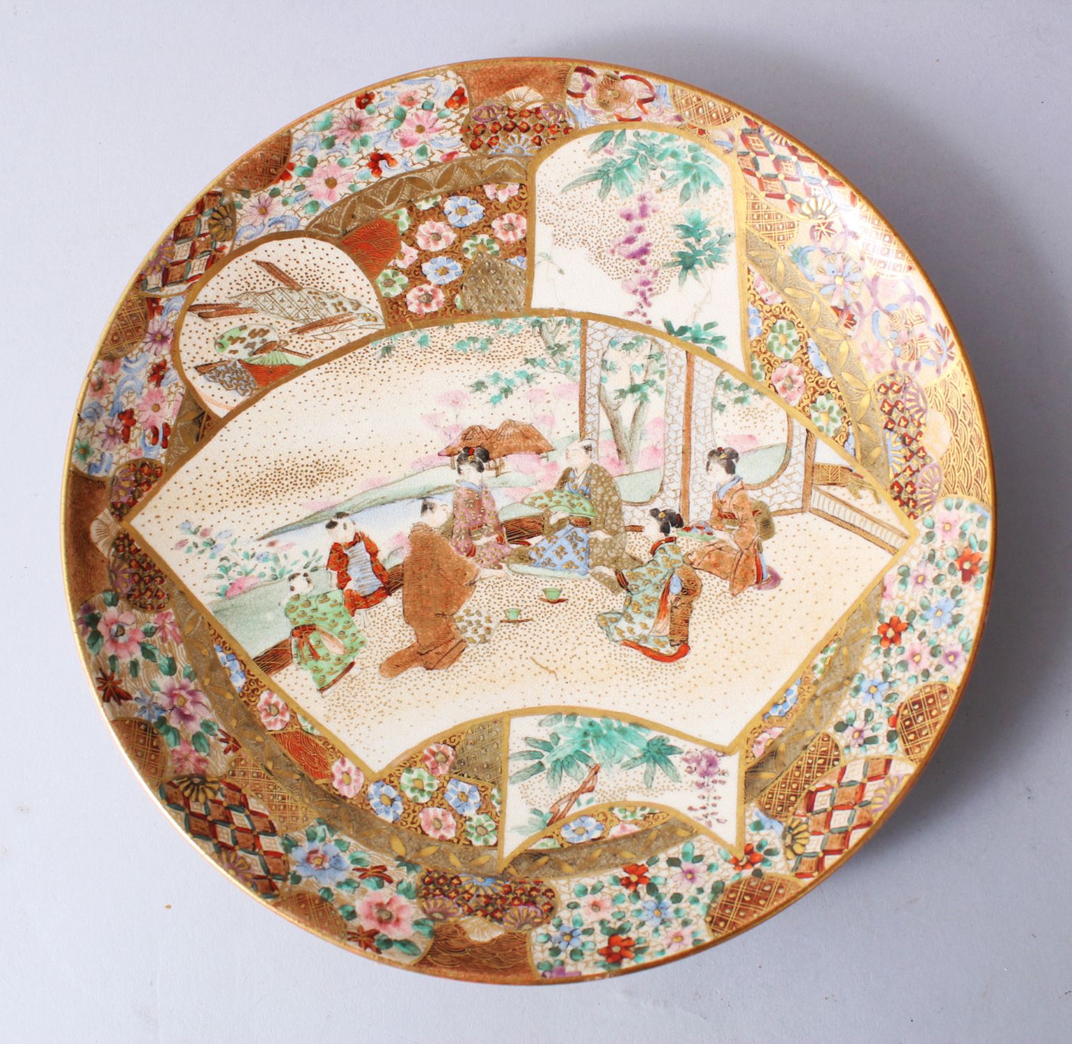 A GOOD JAPANESE MEIJI PERIOD SATSUMA PORCELAIN PLATE, decorated with panels of figures by