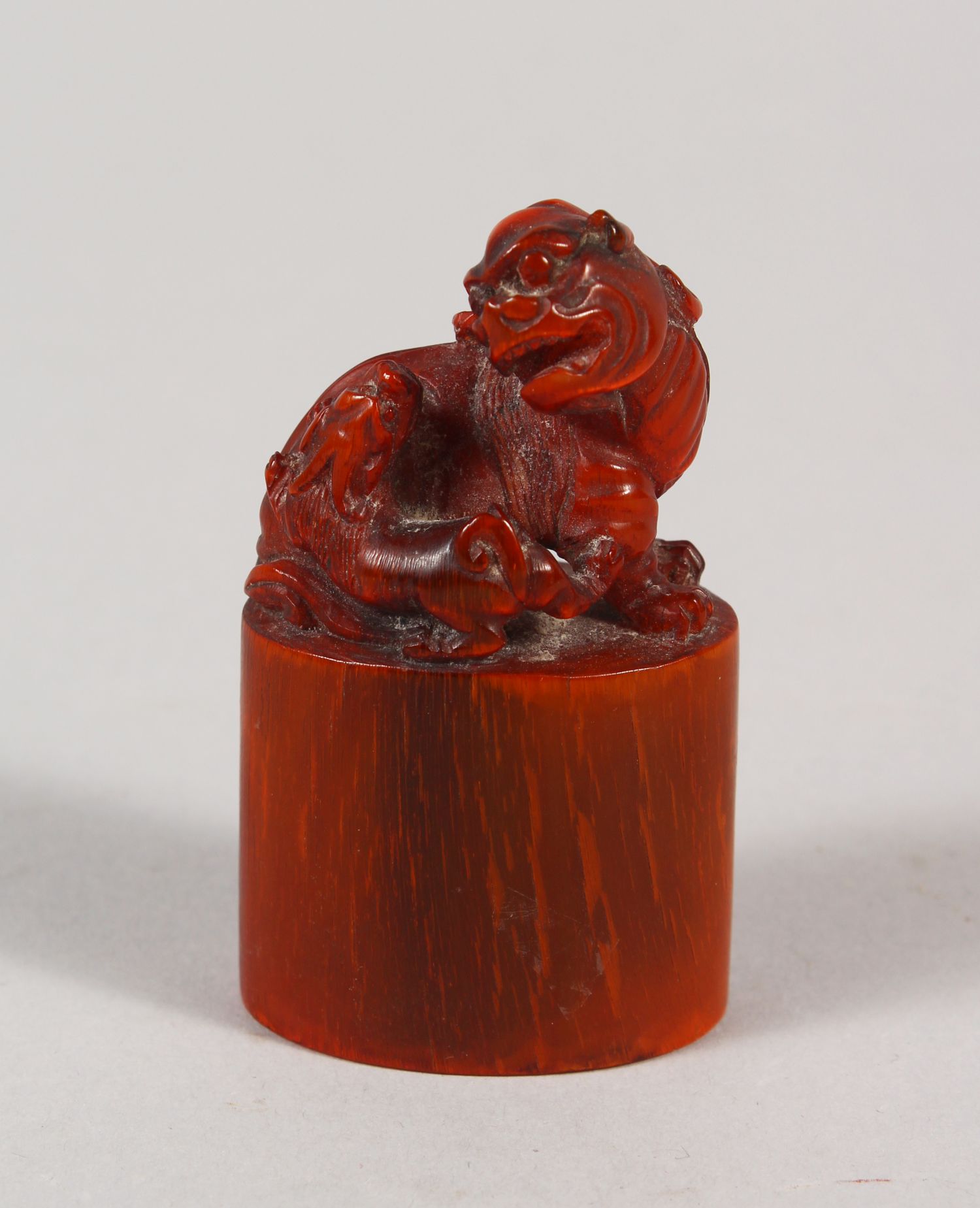 AN EARLY 20TH CENTURY CHINESE HORN SEAL, well carved with a Buddhistic lion and pup on an oval-