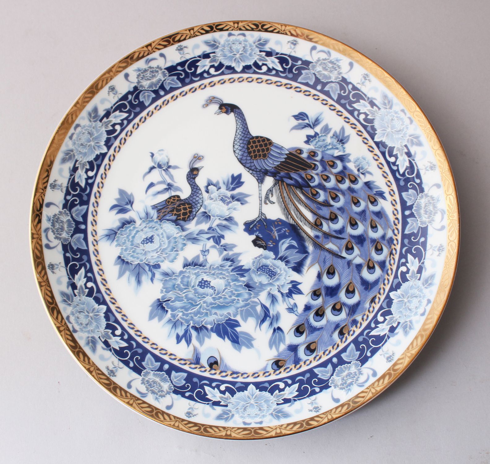 A 20TH CENTURY JAPANESE BLUE & WHITE PEACOCK PORCELAIN PLATE, decorated with scenes of peacocks