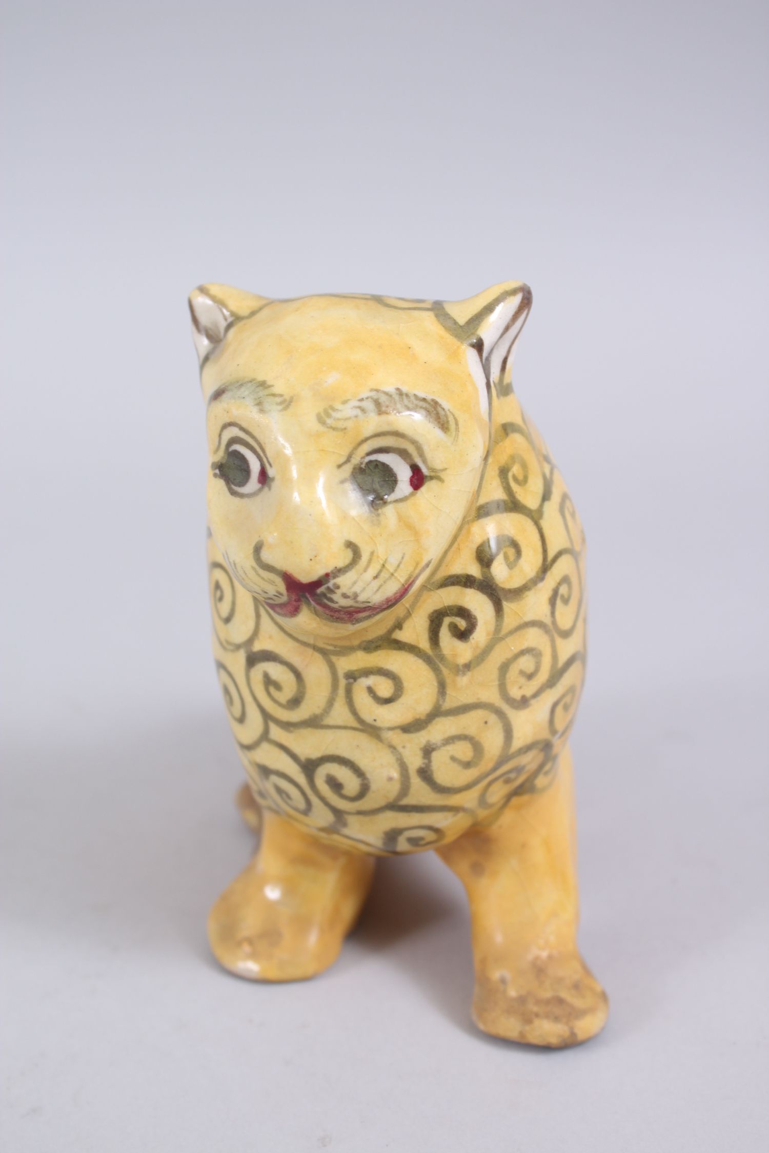 A 19TH CENTURY YELLOW GLAZED PERSIAN LION, with stylized painted mane design, 14cm high x 14,5cm - Image 2 of 6