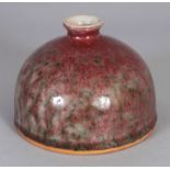 A CHINESE PEACH BLOOM PORCELAIN BEEHIVE WATER POT, the red streaked glaze with green inclusions,