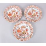 THREE CHINESE 18TH CENTURY ROUGE DE FER PORCELAIN PLATES, decorated with scenes of lion dogs amongst