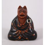 A JAPANESE EDO PERIOD BOXWOOD NETSUKE OF A FOX DISGUISED AS A PRIEST, in a seated position with