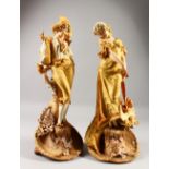 A GOOD PAIR OF DUX PORCELAIN FIGURES OF A YOUNG GALLANT AND YOUNG GIRL in gilt garb and dress,