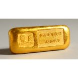 A CHINESE GOLD COLOUR INGOT STYLE WEIGHT. 6.5cms wide.