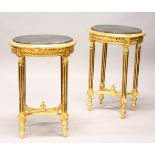 A PAIR OF GILTWOOD AND BLACK MARBLE OVAL STANDS. 50cms wide x 73cms high.