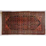 A PERSIAN CARPET, dark blue ground with stylized floral decoration. 290cms x 155cms.
