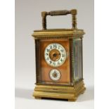 A MINIATURE BRASS CARRIAGE CLOCK, with alarm and subsidiary dial. 12cms high.
