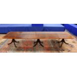 A GOOD REGENCY DESIGN MAHOGANY AND SATINWOOD BANDED TRIPLE PILLAR DINING TABLE, the rounded