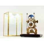 A BRASS SKELETON CLOCK WITH MOONPHASE MOVEMENT, in a glass case. 50cms high.