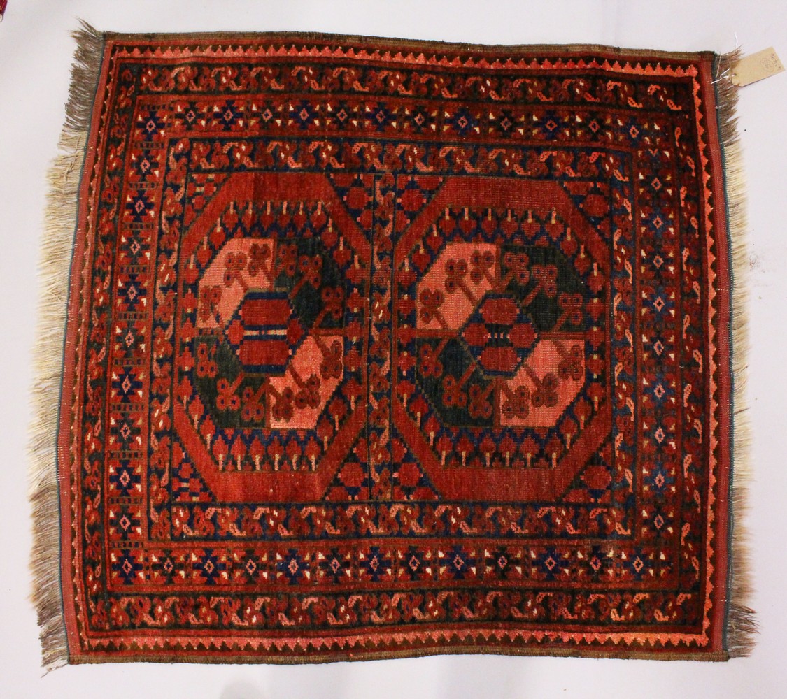 A SMALL PERSIAN RUG, rust ground with two large motifs. 106cms x 100cms.