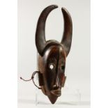 A LONG NATIVE CARVED WOOD HEAD MASK with horns. 51cms long.