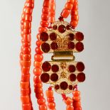 A CORAL NECKLACE, with ornate gold clasp.