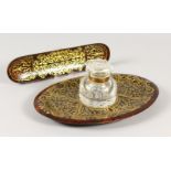 A GOOD BOULLE BRASS INLAID OVAL INKSTAND with glass inkwell and pen tray. 27cms long.
