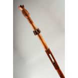AN AFRICAN CARVED WOOD CHIEFS STAFF, with figural top and carved and pierced shaft. 122cms long.