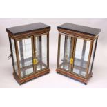 A PAIR OF STANDING DISPLAY CABINETS, with black marble tops, each with a pair of glazed doors and