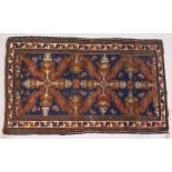 A PERSIAN RUG, blue ground with stylized motifs in a conforming border. 218cms x 130cms.