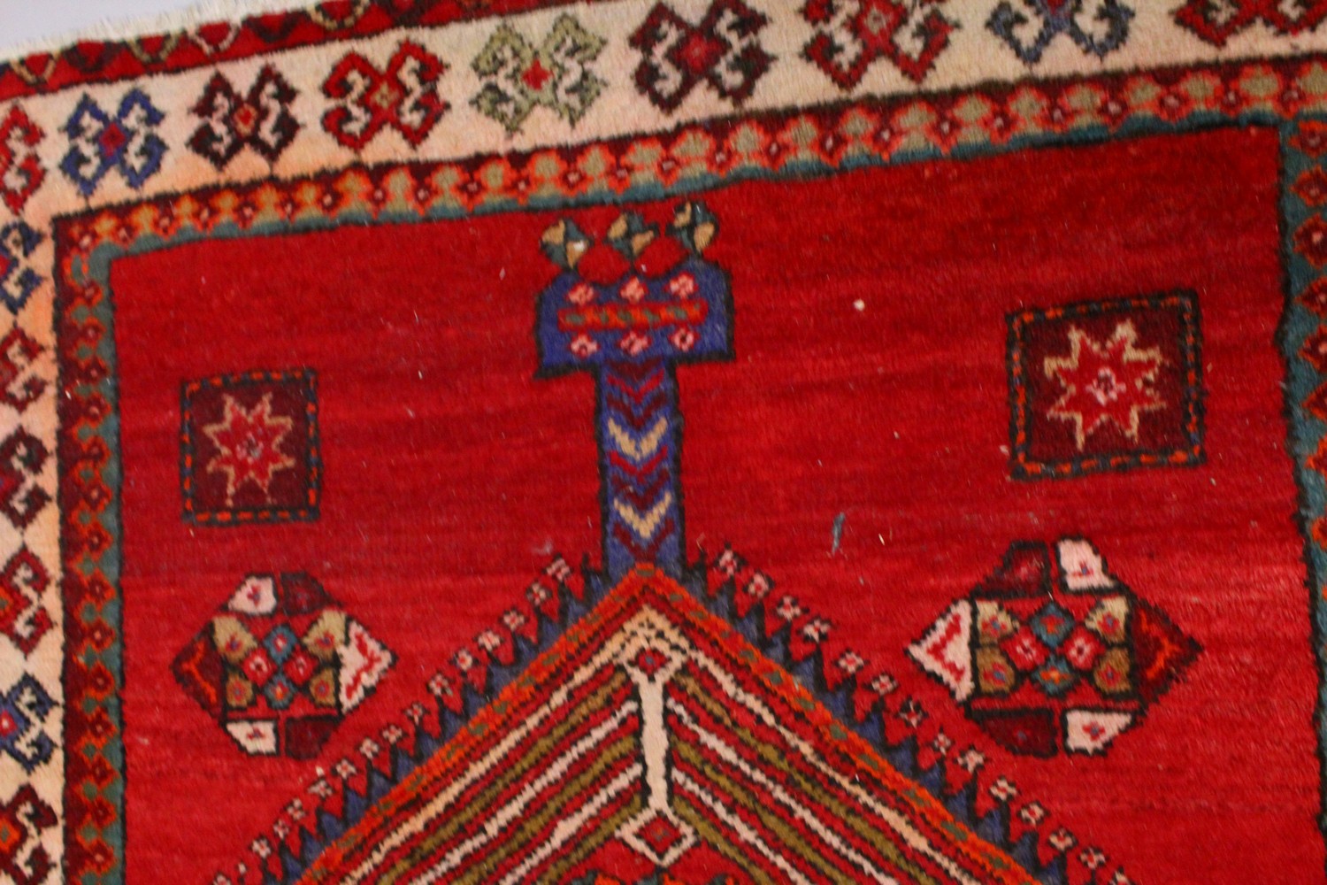 A PERSIAN LONG CARPET / RUNNER, bright red ground with three blue ground motifs in a stylized - Image 4 of 8