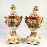 A PAIR OF MEISSEN STYLE FLORAL ENCRUSTED VASES, COVERS AND STANDS. 73cms high.