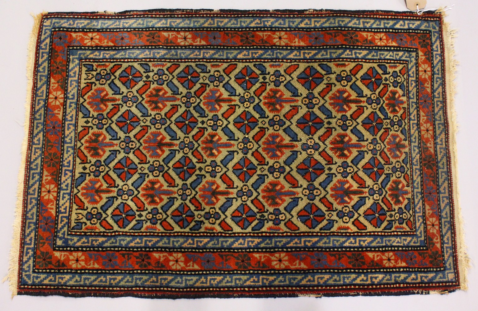 A SMALL PERSIAN RUG, beige ground with allover stylized decoration. 100cms x 65cms.