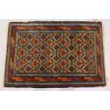 A SMALL PERSIAN RUG, beige ground with allover stylized decoration. 100cms x 65cms.