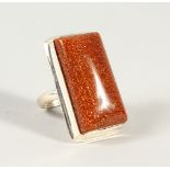 A SILVER AND GOLDSTONE RING.