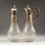 A GOOD PAIR OF GERMAN SCHLUND .800 SILVER AND GLASS CLARET JUGS.