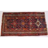A PERSIAN RUG, dark blue ground with geometric decoration (reduced in length). 200cms x 110cms.