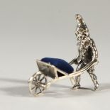 A SILVER GNOME AND WHEELBARROW PIN CUSHION. 4cms long.