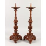 A GOOD PAIR OF BAROQUE WOOD PRICKET CANDLESTICKS. 56cms high.