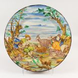 A LARGE ISTORIATO MAIOLICA CIRCULAR CHARGER, painted with figures and goats. 50cms diameter.