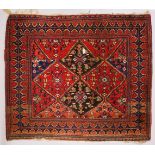 A PERSIAN SQUARE SHAPE RUG, with stylized motifs and broad border (altered). 140cms x 160cms.