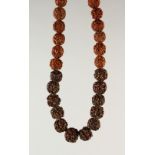 A CHINESE CARVED NUT BEAD NECKLACE. 66cms long.