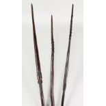 THREE PAPUA NEW GUINEA CARVED BARBED SPEARS, undecorated. Longest: 8ft 9ins (3).