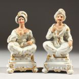 A PAIR OF PARIS PORCELAIN SPICE VASES as seated TURKISH MAN and WOMAN, sitting cross-legged on