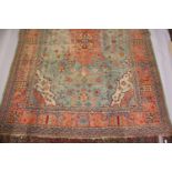 A LARGE HERIZ CARPET, pale blue ground, salmon pink central motif in a confirming border (worn). 4.