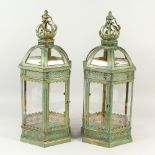 A PAIR OF ORNATE GREEN COLOURED HANGING LANTERNS. 64cms high.