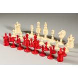 A RED AND WHITE STAINED IVORY CHESS SET.