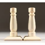 A PAIR OF ART DECO IVORY CANDLESTICKS on square bases. 4.5ins high.