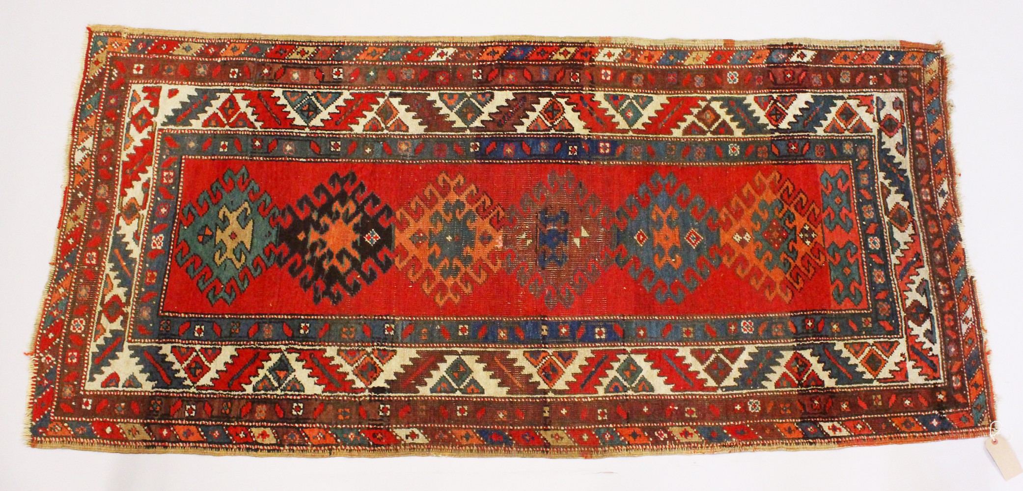 A PERSIAN RUG, red ground with six medallions, in a quadruple border. 200cms x 96cms.