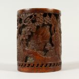 A CHINESE BRONZE BRUSHPOT, decorated with figures in a landscape. 14cms high.