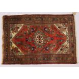 A SMALL PERSIAN RUG, rust ground with stylized decoration. 90cms x 2cms.