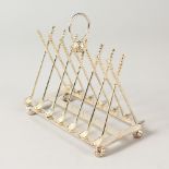 A "GOLFING" SIX-DIVISION TOAST RACK, with cross clubs and balls. 16cms long.