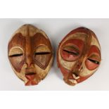 TWO RED AND WHITE PIGMENT MASKS. 28cms long.