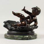 A SMALL PAINTED SPELTER CHERUB. Modern production. 16cms long, on a marble base.