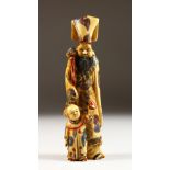 A CHINESE CARVED AND STAINED IVORY FIGURE OF A MAN WITH A BOY. 7ins high.
