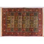 A GOOD PERSIAN RUG, with five rows of eight panels, each decorated with trees and flowers, in a